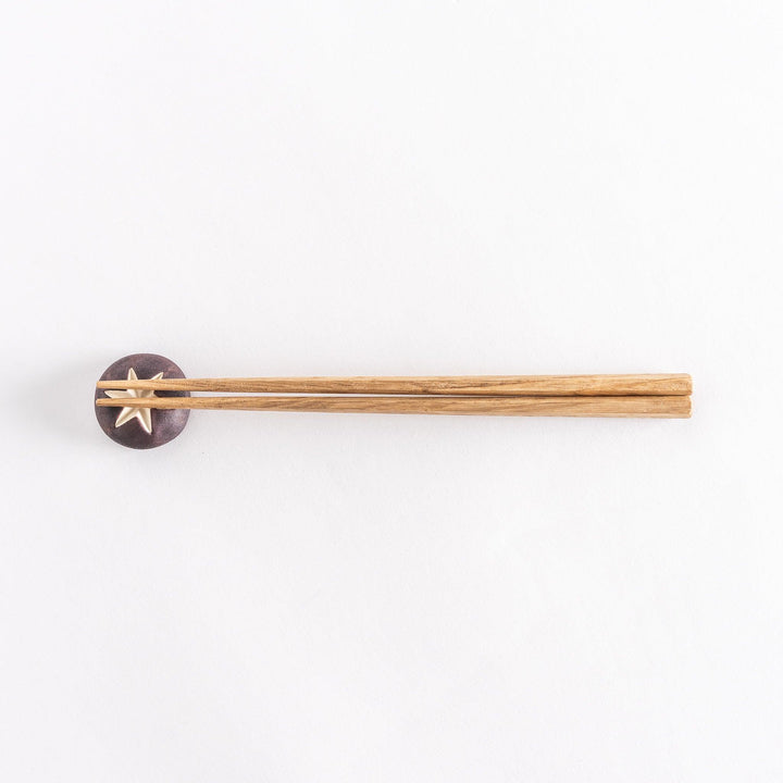 Full view of chopsticks placed on the mushroom-shaped rest.
