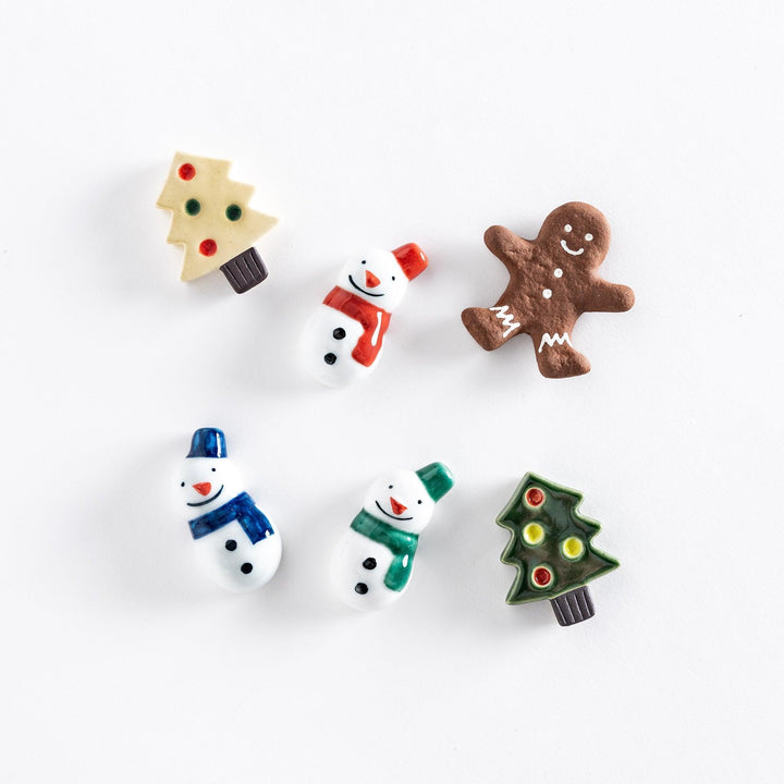 Festive holiday chopstick rests in various shapes, including snowmen with scarves, Christmas trees with ornaments, and a gingerbread cookie.