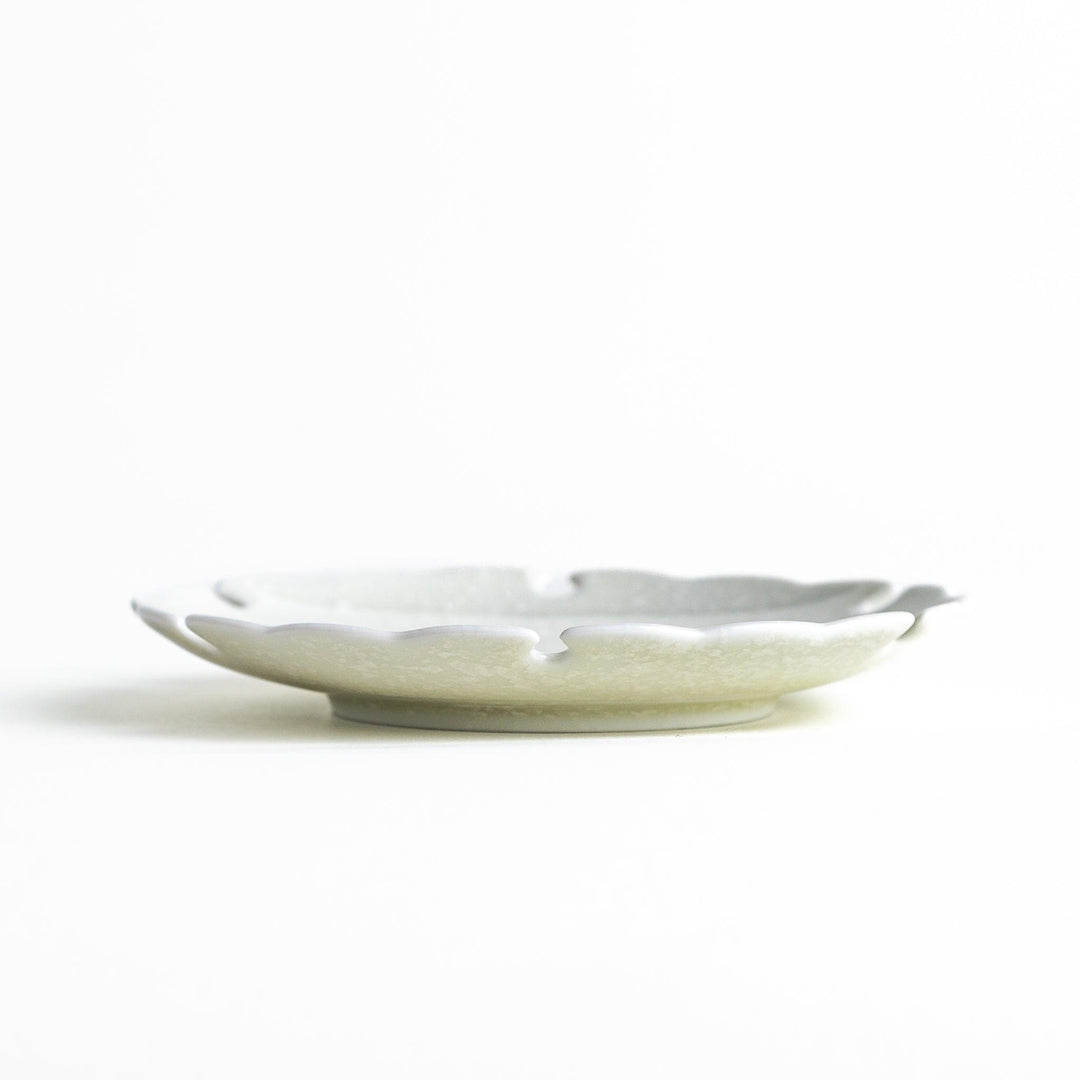 Ceramic sauce dishes with scalloped edges, available in black and white.