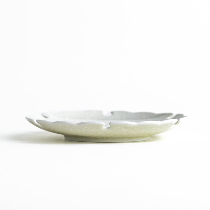 Ceramic sauce dishes with scalloped edges, available in black and white.
