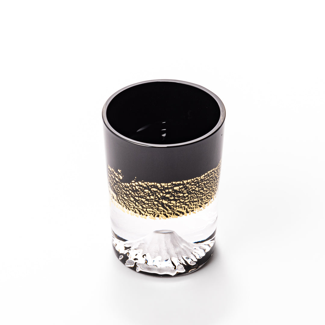 Black and clear sake glass with striking gold-leaf landscape and a Mount Fuji sculpture at the base, offering a bold take on Japanese elegance.