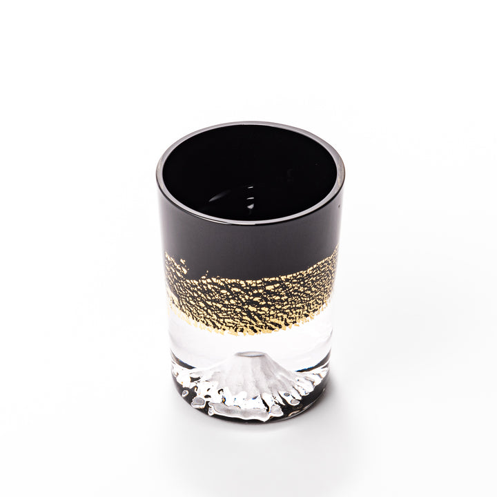 Black and clear sake glass with striking gold-leaf landscape and a Mount Fuji sculpture at the base, offering a bold take on Japanese elegance.