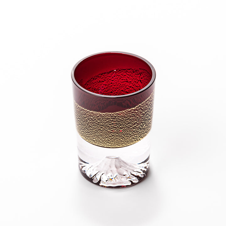 Deep red sake glass adorned with rich gold-leaf mountain scenery and a sculpted Mount Fuji at the base, offering a refined Japanese aesthetic.