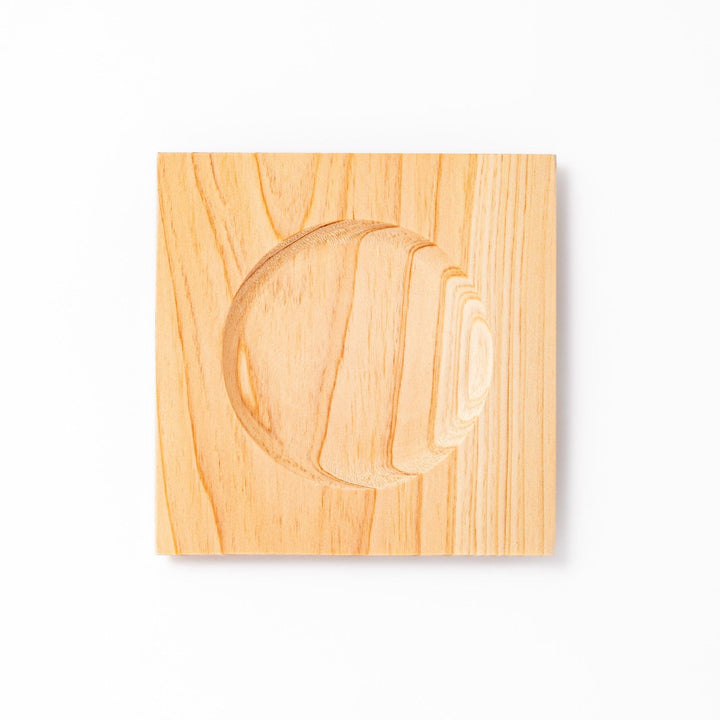 Square hinoki wood coaster with recessed circular center and beveled edge, featuring natural grain for elegant cup support.