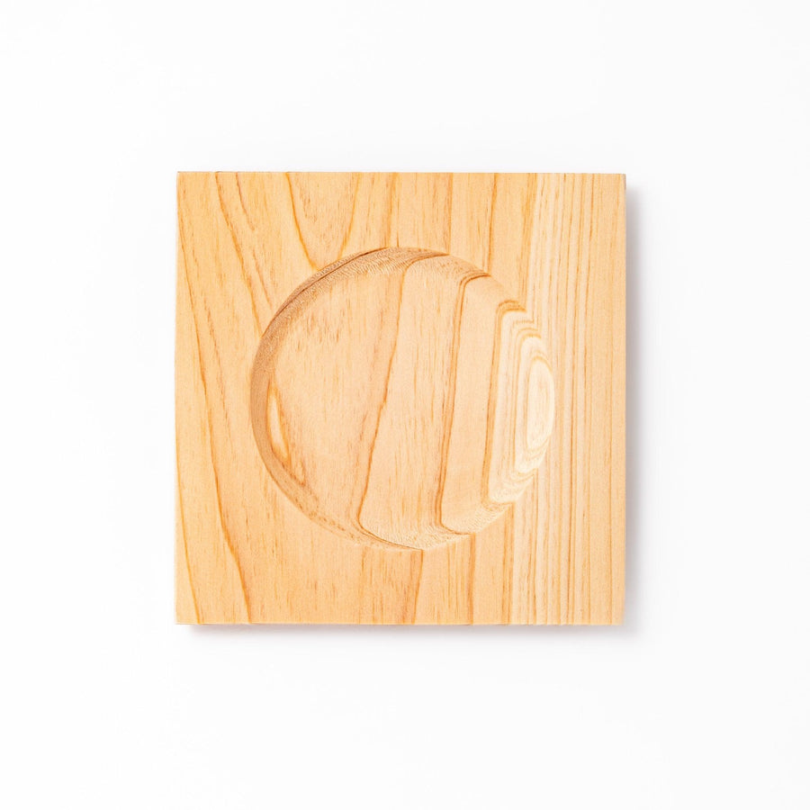 Square hinoki wood coaster with recessed circular center and beveled edge, featuring natural grain for elegant cup support.