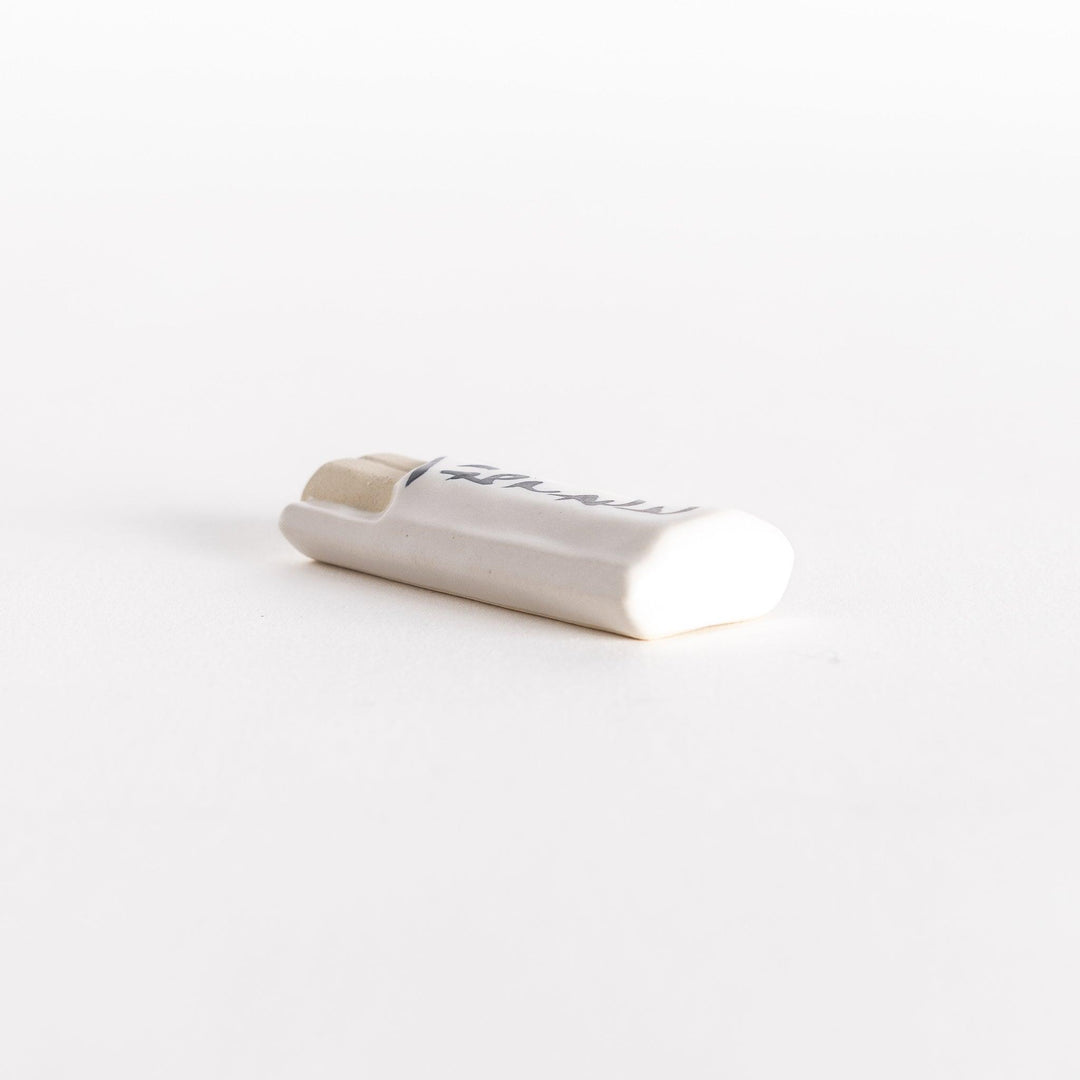 Side view of the to-go bag-shaped ceramic chopsticks rest, showcasing its curved form.
