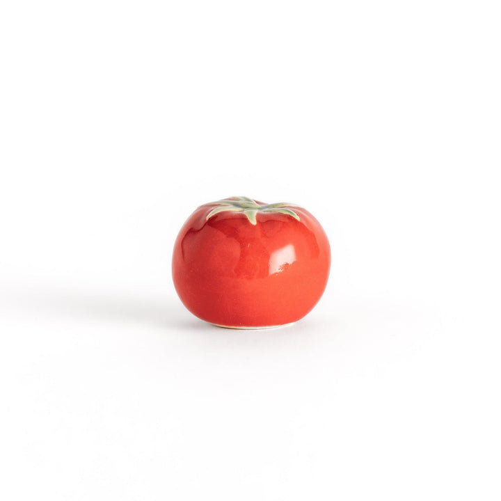Glossy red ceramic tomato chopstick rest with a green stem detail, adding a playful yet elegant touch to your tableware setting.
