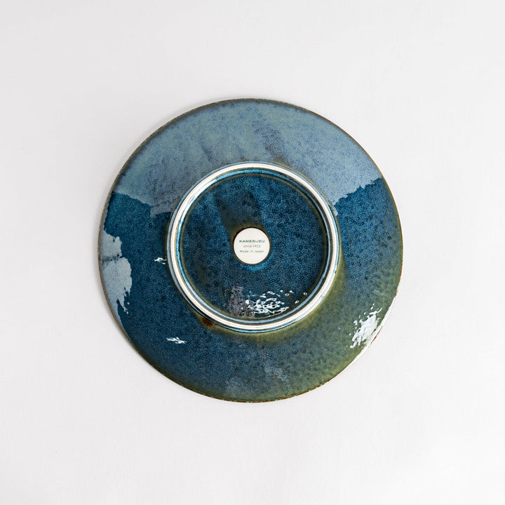 A round salad plate featuring a deep blue color and a fine speckled texture.