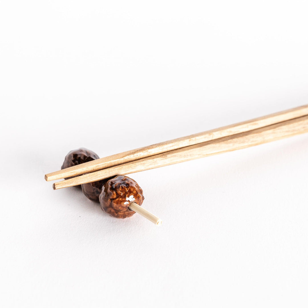 Close-up of chopsticks resting on the tsukune meatball chopsticks rest.
