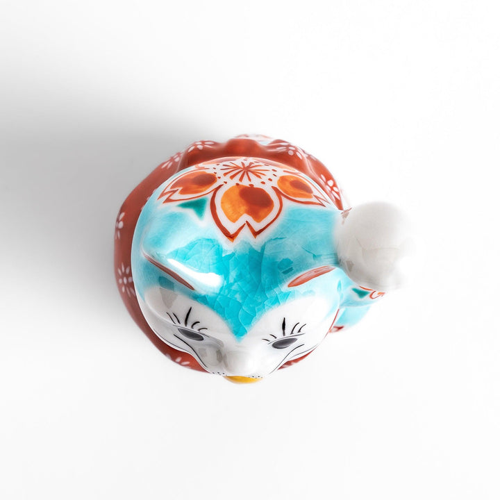 Vibrant Turkish blue Maneki Neko figurine adorned with floral patterns in orange and white, featuring a golden bell and a raised paw, symbolizing good fortune and prosperity.