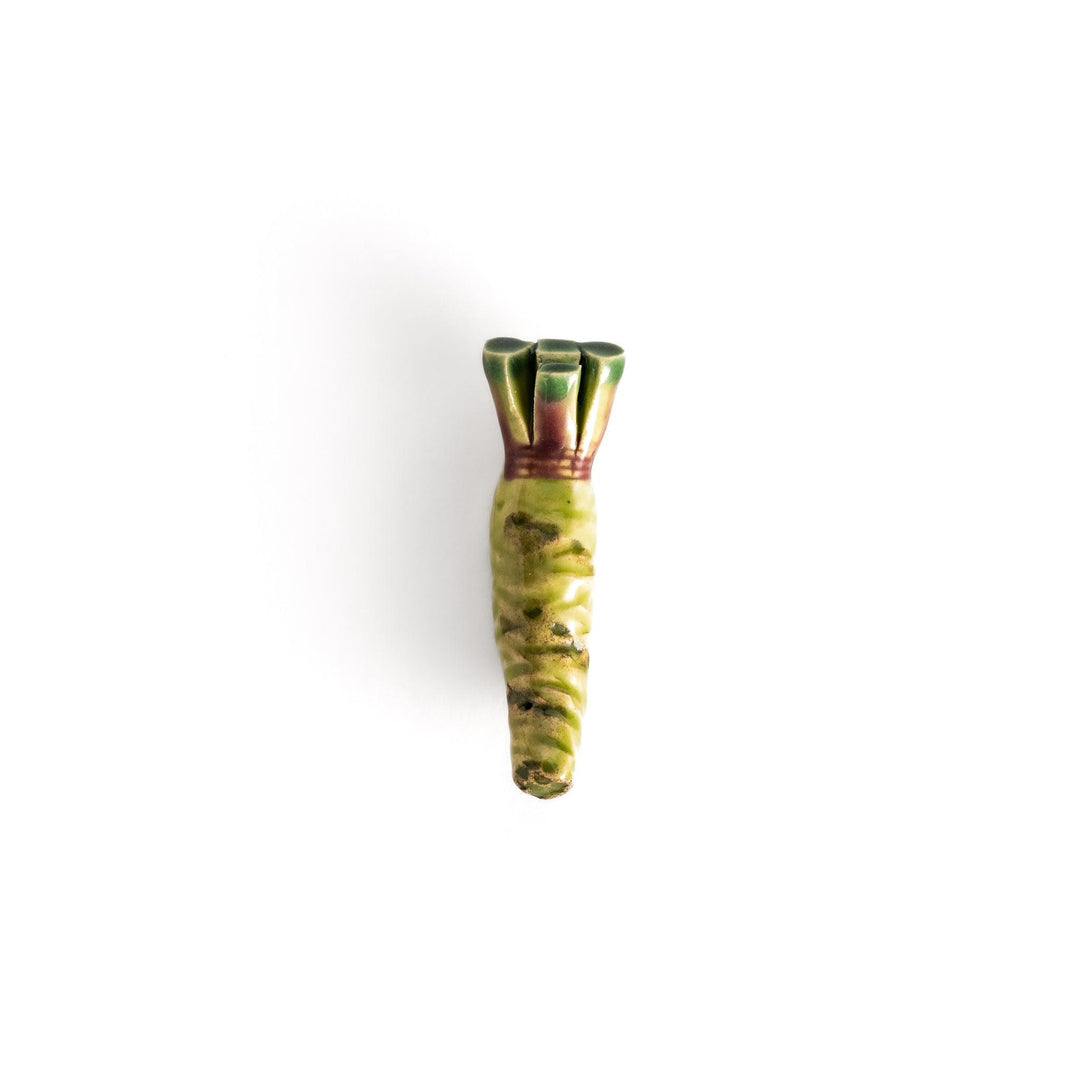 Ceramic wasabi chopstick rest in green tones, featuring intricate details that mimic the texture and shape of real wasabi roots.