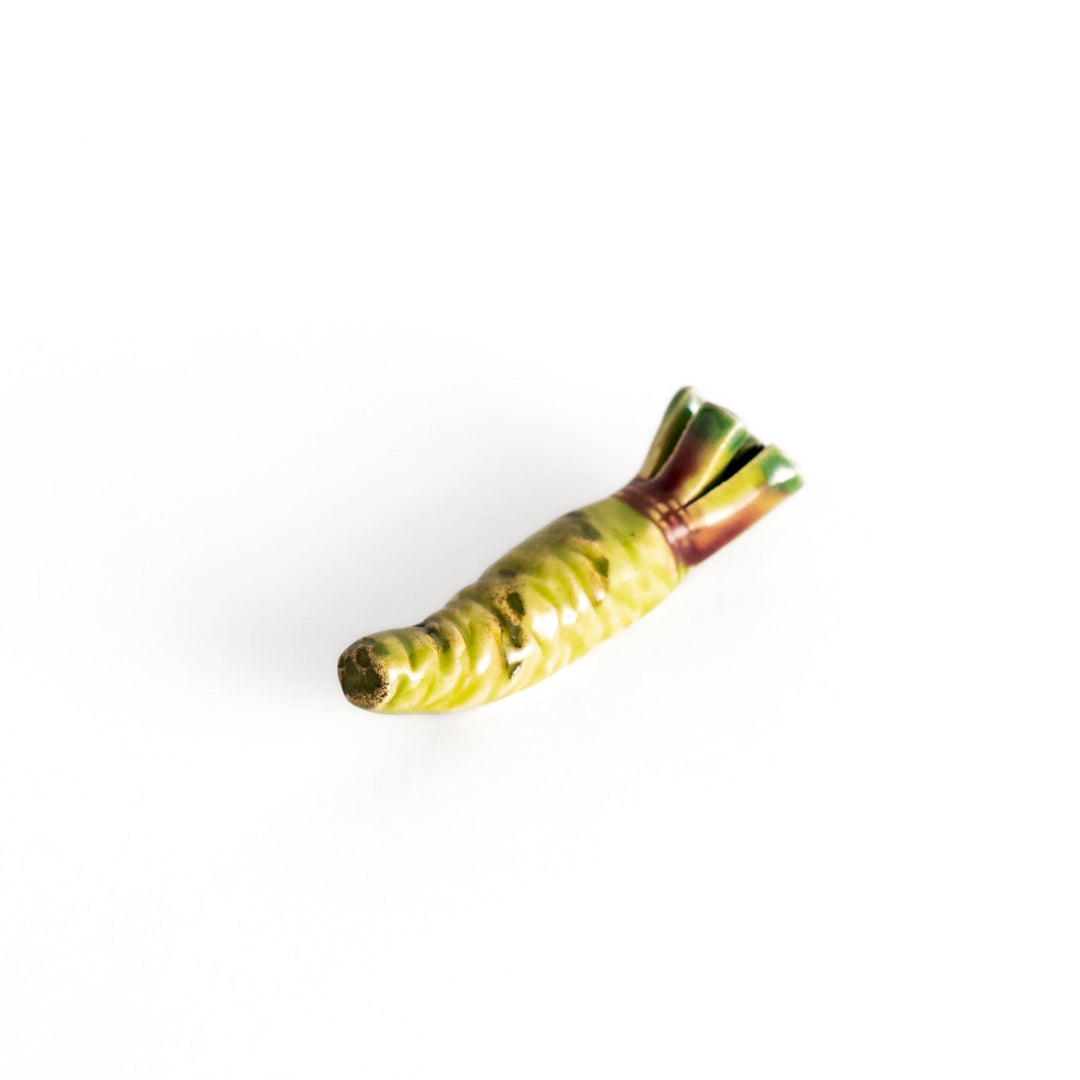 Ceramic wasabi chopstick rest in green tones, featuring intricate details that mimic the texture and shape of real wasabi roots.