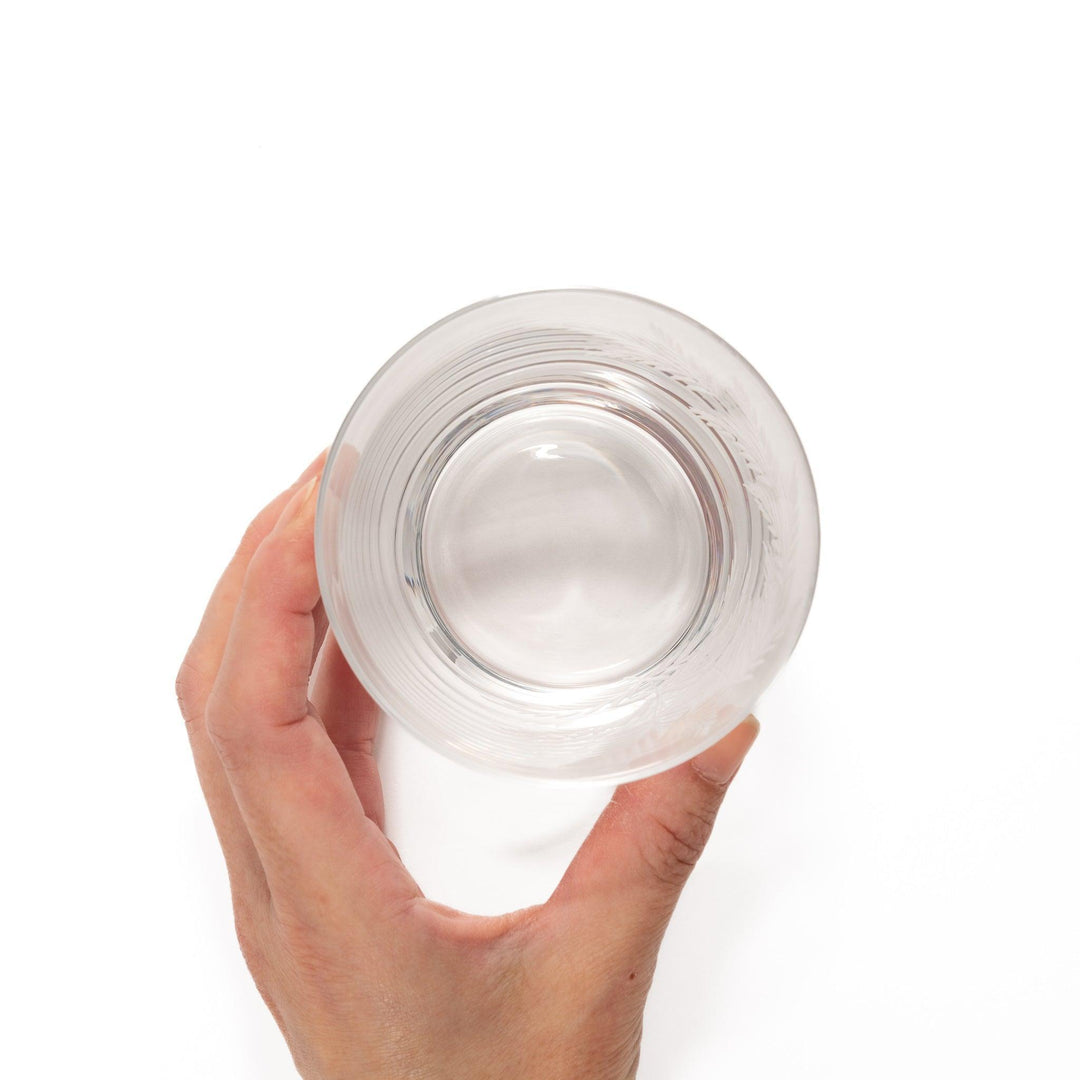 Elegant rocks glass with delicate fern engravings, offering a sophisticated design perfect for serving whiskey or other drinks.