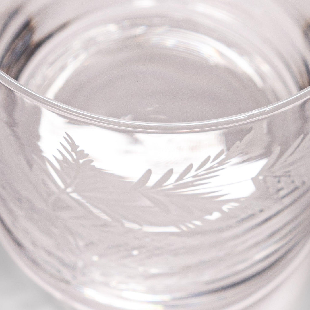 Elegant rocks glass with delicate fern engravings, offering a sophisticated design perfect for serving whiskey or other drinks.