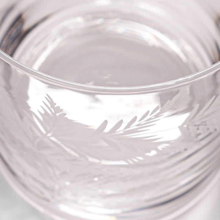 Elegant rocks glass with delicate fern engravings, offering a sophisticated design perfect for serving whiskey or other drinks.