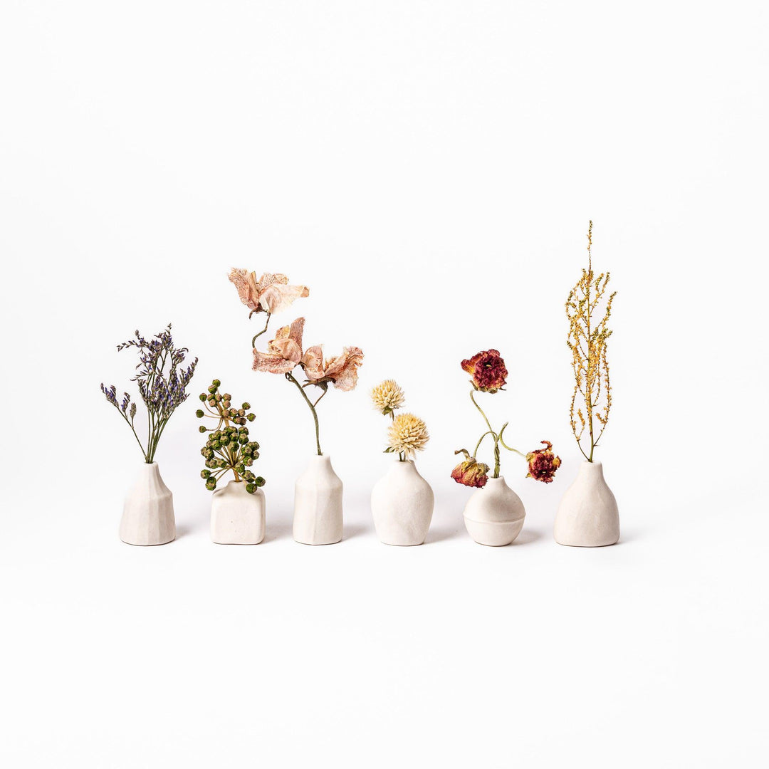 Minimalist white ceramic bud vases with dried flowers, ideal for Japanese-inspired interiors and simple, elegant home decoration.
