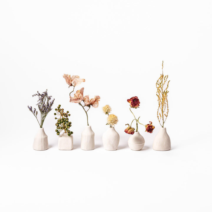 Minimalist white ceramic bud vases with dried flowers, ideal for Japanese-inspired interiors and simple, elegant home decoration.