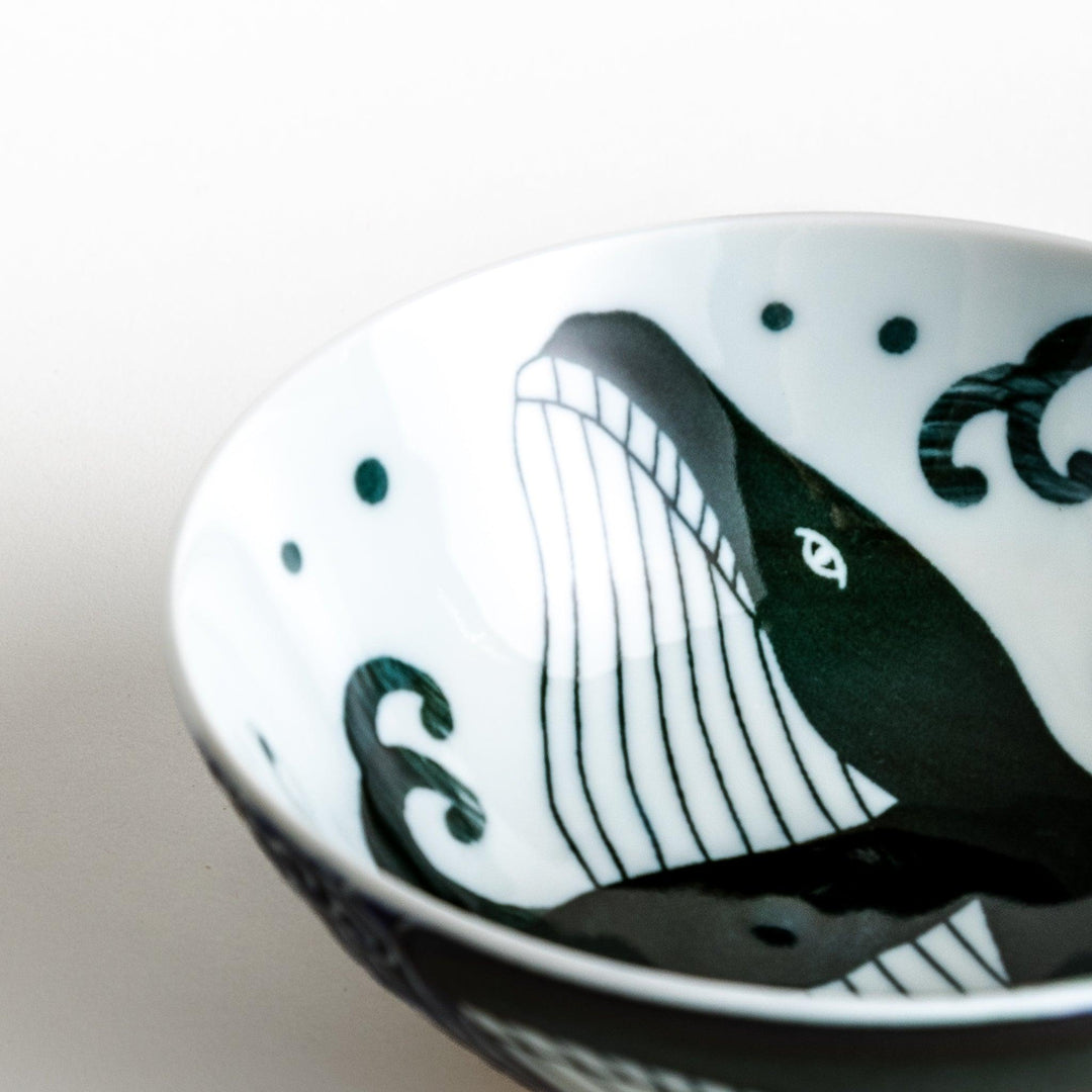 A large rice bowl with a whale and wave design in blue on a white background.