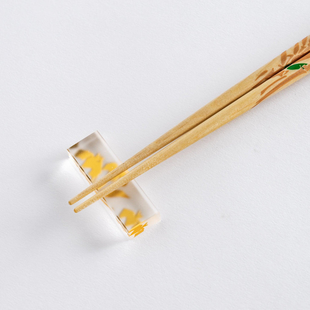 Chopsticks with wisteria and bamboo design, placed on a clear holder.