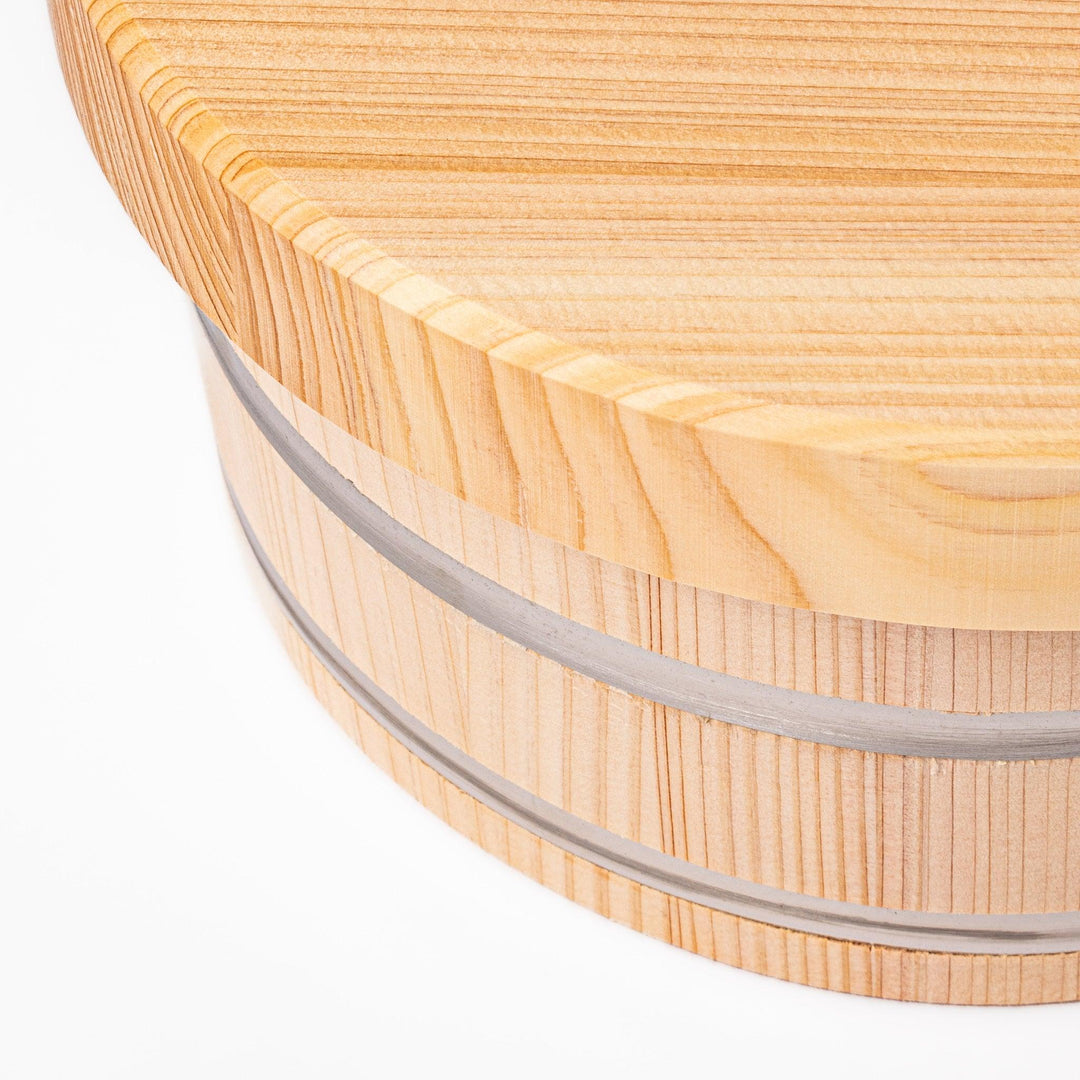 Wooden rice container with lid and paddle, made from natural wood with metal bands, ideal for storing and serving freshly cooked rice.