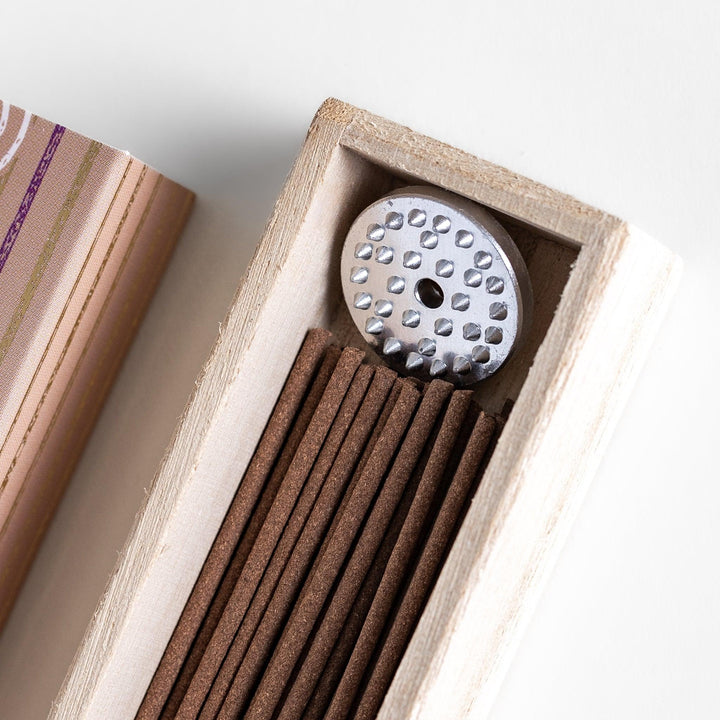 Woodland Palo Santo Incense in a light wooden box with warm brown sticks, elegantly packaged in a soft beige design featuring white circular patterns, evoking a calming and purifying Palo Santo aroma.