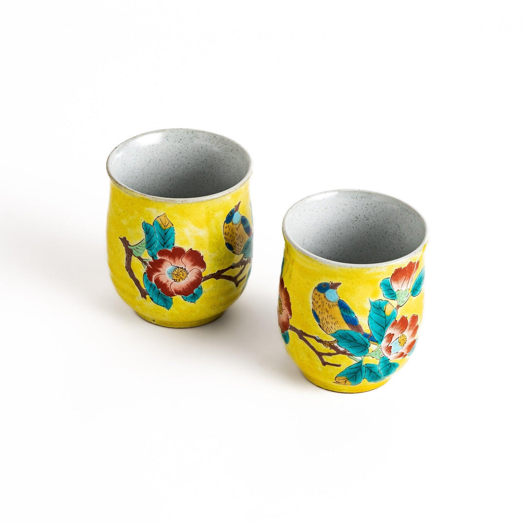 Two yellow teacups with a beautiful bird and flower design, perfect for sharing a moment with a loved one.