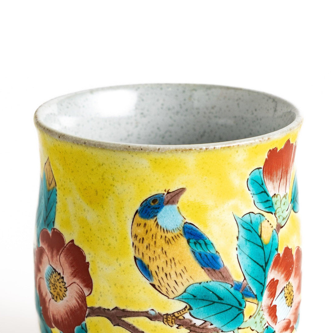 Yellow teacup with a colorful bird perched on a flowering branch, perfect for adding a touch of nature to your tea time.