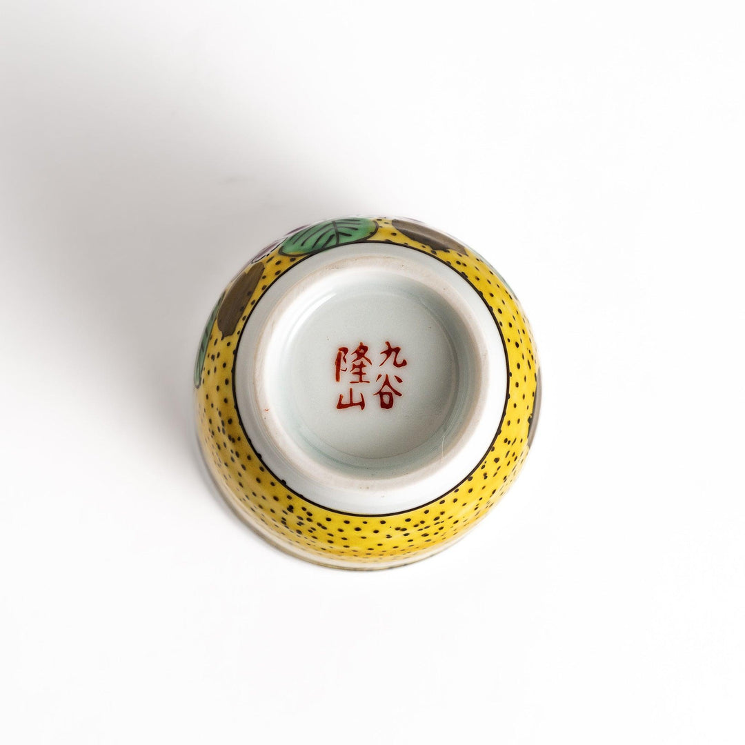 Yellow teacup with a colorful hydrangea pattern and green leaves, perfect for enjoying a cup of tea.